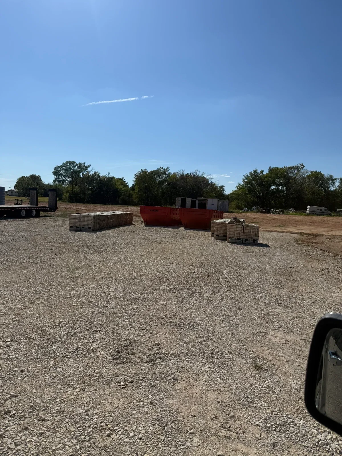 Gravel parking lot with compacted stone surface and mature tree landscaping
